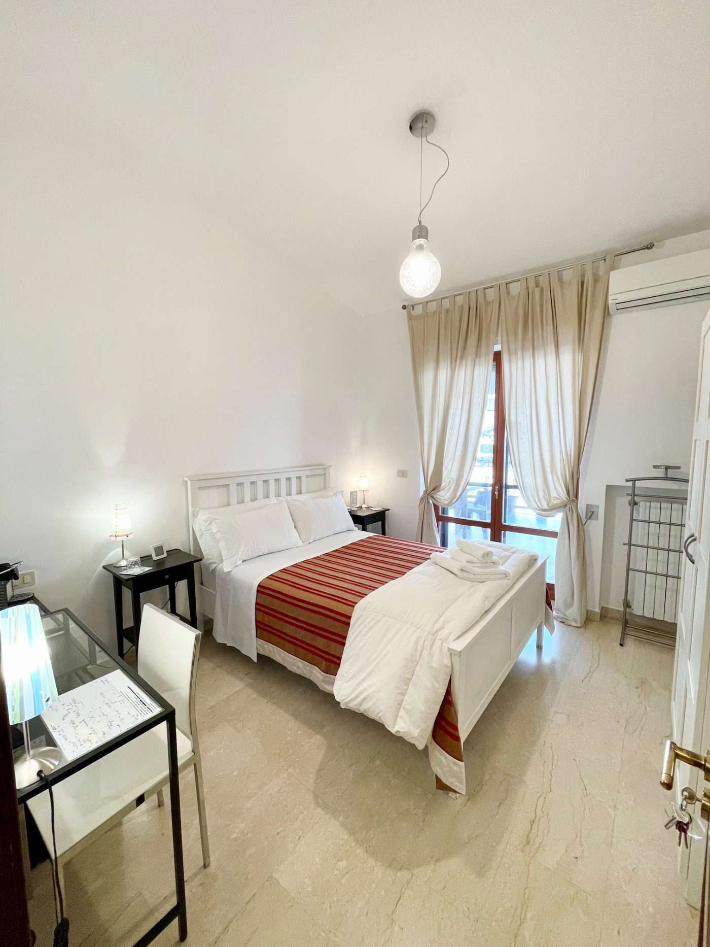 Piccola matrimoniale con letto alla francese e balcone del B&B Le Saline